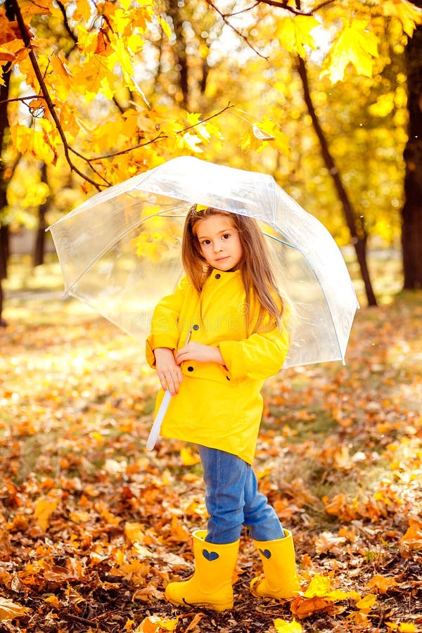 Glückliches Kindermädchen mit einem Regenschirm und Gummistiefel ein Herbst gehen lizenzfreie stockfotos Glückliches Kindermädchen mit einem Regenschirm und Gummistiefel ein Herbst gehen lizenzfreie stockfotos