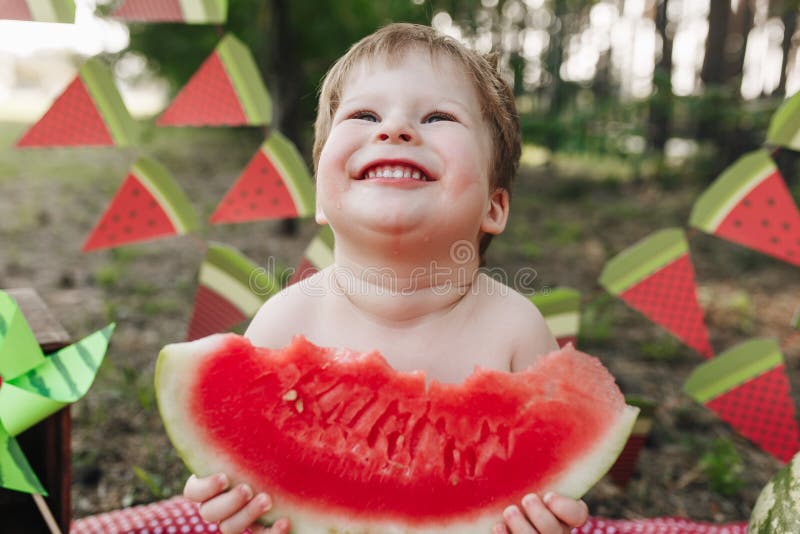 Glückliches kleines Baby, welches die Wassermelone im Freien isst lizenzfreie stockfotografie Glückliches kleines Baby, welches die Wassermelone im Freien isst lizenzfreie stockfotografie