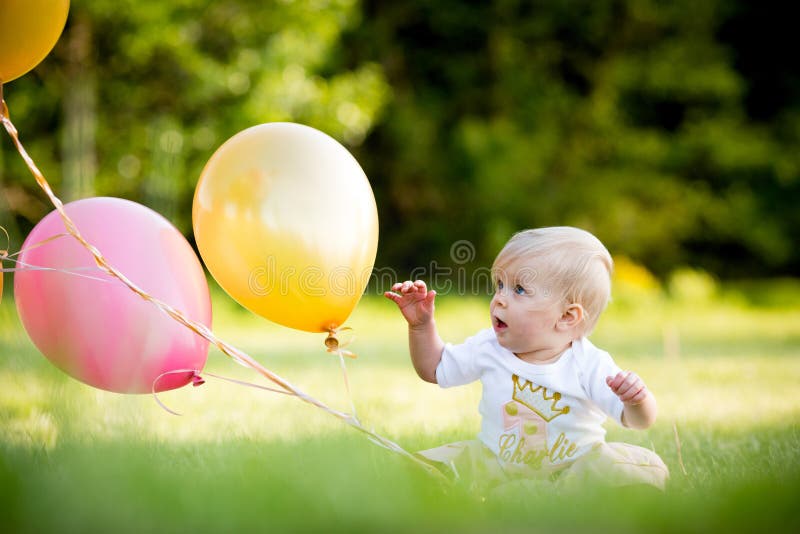Glückliches kleines blondes kaukasisches Mädchen draußen mit Ballonen stockfotos Glückliches kleines blondes kaukasisches Mädchen draußen mit Ballonen stockfotos