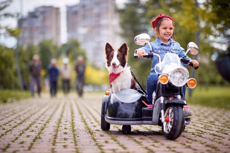 Glückliches kleines Mädchen, das in einem Spielzeug motocycle wird lizenzfreies stockbild