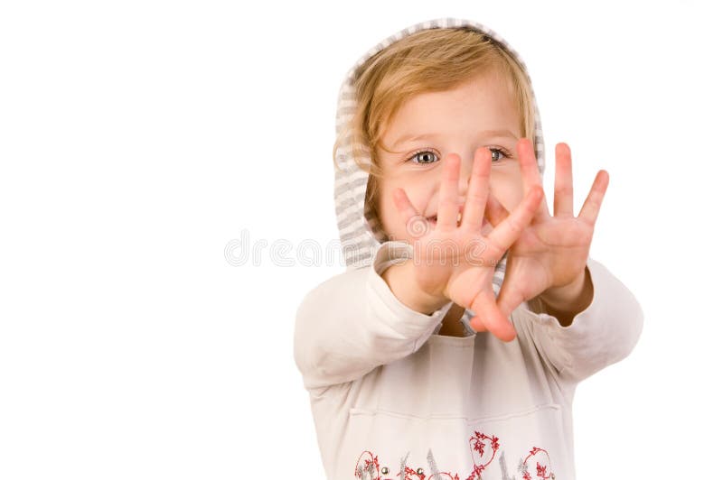 Glückliches kleines Mädchen des smiley, das ihre Hände betrachtet stockbild Glückliches kleines Mädchen des smiley, das ihre Hände betrachtet stockbild
