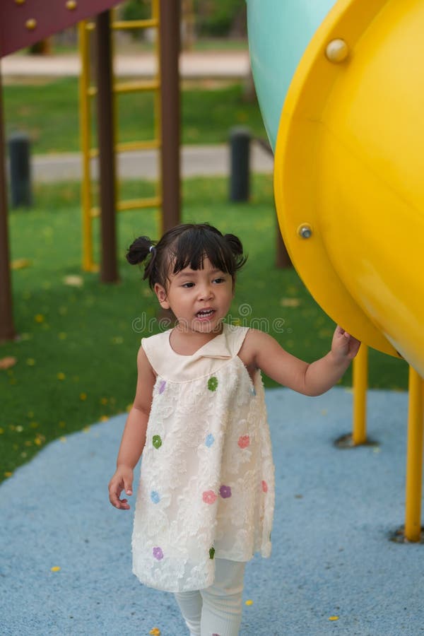 Glückliches Kleinkind, das auf einem Spielplatz im Freien spielt lizenzfreies stockfoto