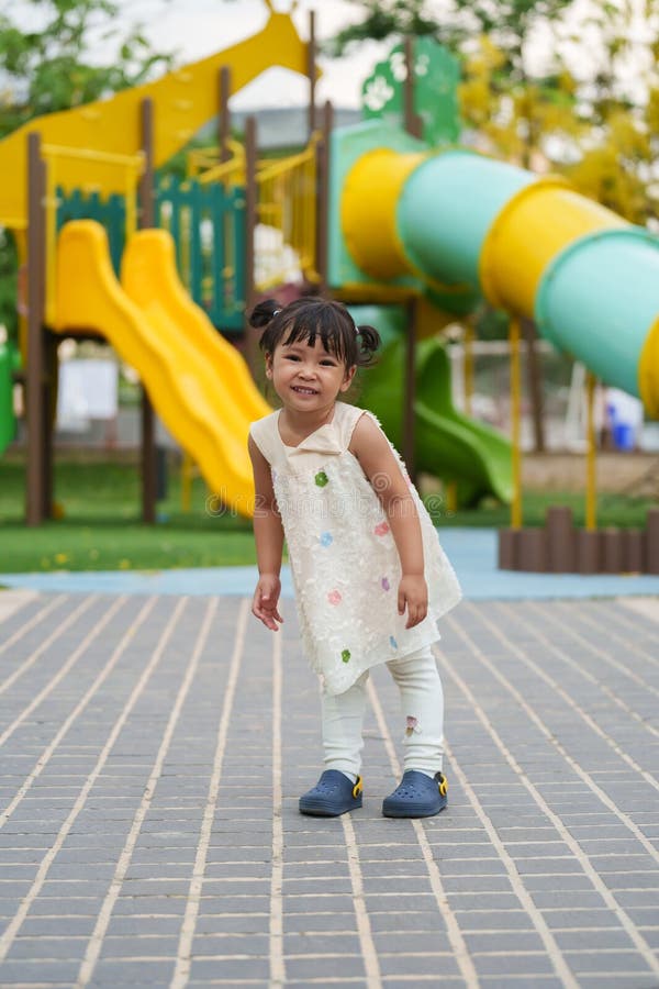 Glückliches Kleinkind, das auf einem Spielplatz im Freien spielt stockfoto