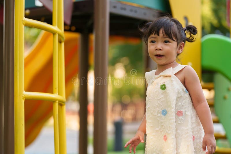 Glückliches Kleinkind, das auf einem Spielplatz im Freien spielt lizenzfreie stockfotos
