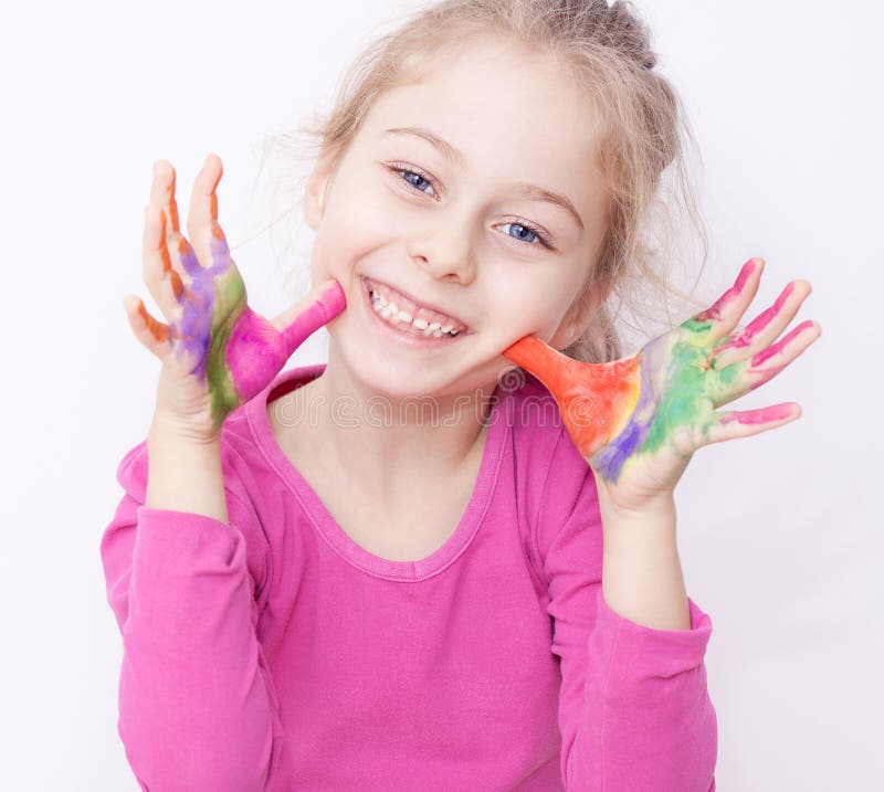 Glückliches lächelndes Kindermädchen, das Spaß mit den gemalten Händen hat lizenzfreie stockbilder Glückliches lächelndes Kindermädchen, das Spaß mit den gemalten Händen hat lizenzfreie stockbilder