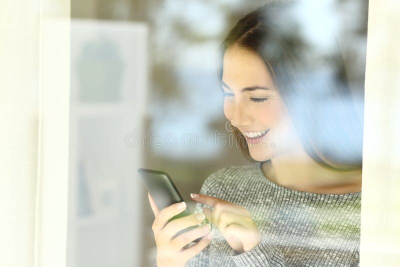 Glückliches Mädchen, das intelligenten Telefoninhalt auf Linie überprüft stockfotos Glückliches Mädchen, das intelligenten Telefoninhalt auf Linie überprüft stockfotos
