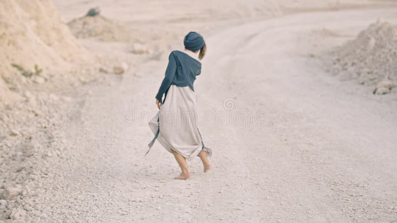 Glückliches Mädchen tanzt barfuß an der Unterseite einer Sandgrube