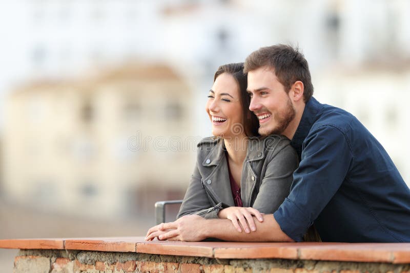 Glückliches Paar, das im Urlaub Ansichten in eine Terrasse genießt