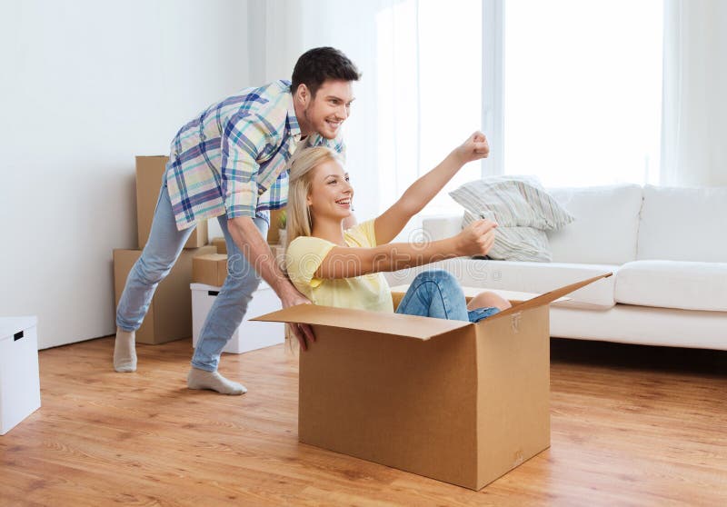 Glückliches Paar, das Spaß mit Kästen am neuen Haus hat stockbild Glückliches Paar, das Spaß mit Kästen am neuen Haus hat stockbild