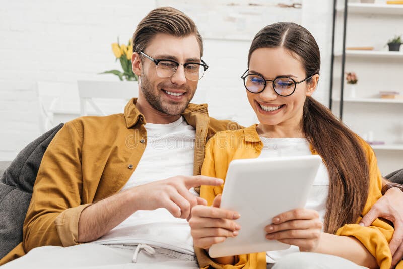 Glückliches Paar, das zusammen Tablette verwendet stockbild