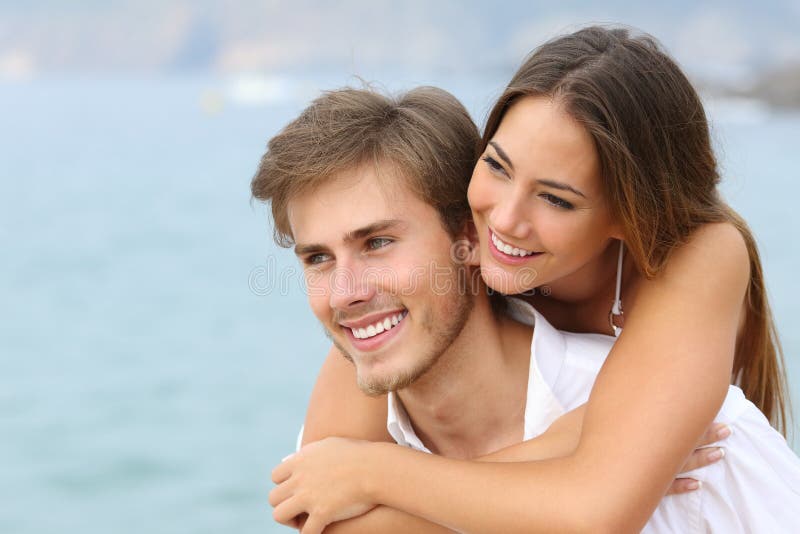 Glückliches Paar in der Liebe mit perfektem Lächeln auf dem Strand