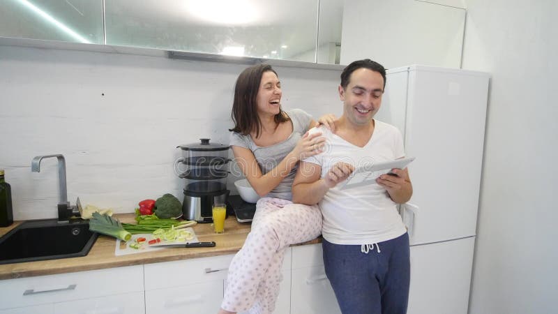 Glückliches Paar mit Tablet-Computer in der Küche zu Hause