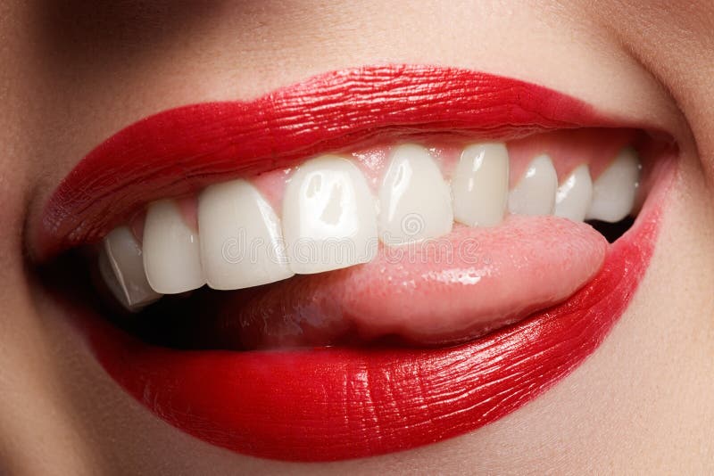 Glückliches weibliches Lächeln der Nahaufnahme mit den gesunden weißen Zähnen, helle rote Lippen richtet her stockbild Glückliches weibliches Lächeln der Nahaufnahme mit den gesunden weißen Zähnen, helle rote Lippen richtet her stockbild