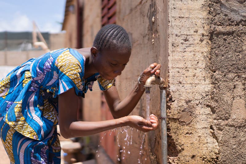 Young African beautiful Children woman girls Standing in front of water tap and getting healthy fresh water in a rural village in Bamako, Mali. Young African beautiful Children woman girls Standing in front of water tap and getting healthy fresh water in a rural village in Bamako, Mali.