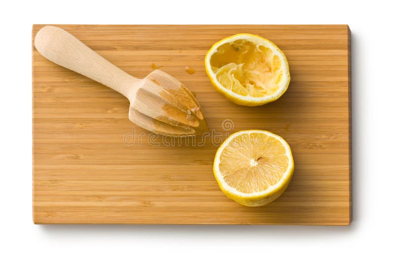 Squeezed lemon fruit and citrus reamer on cutboard. Squeezed lemon fruit and citrus reamer on cutboard