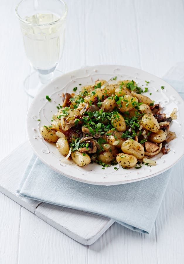 Gnocchi à l'oignon et aux champignons. Fond en bois lumineux. Copiez l'espace.