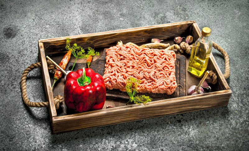 Gnälla köttfärs med kryddor och örter på ett gammalt magasin royaltyfri bild Gnälla köttfärs med kryddor och örter på ett gammalt magasin royaltyfri bild