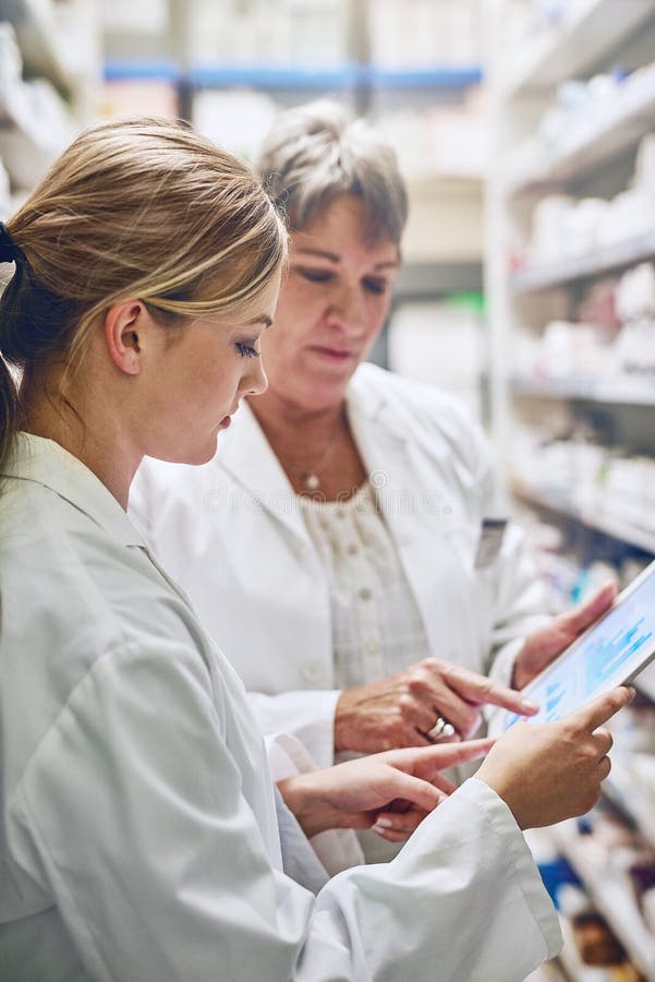 They go the extra mile. pharmacists using a digital tablet together.