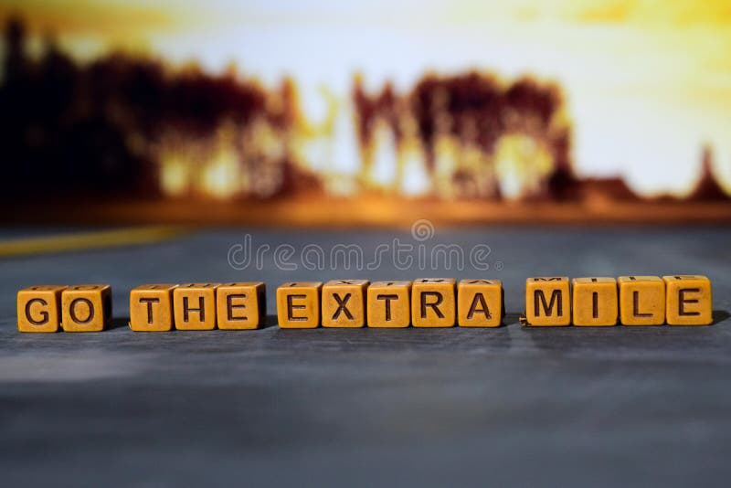 Go the extra mile on wooden blocks. Cross processed image with bokeh background royalty free stock image Go the extra mile on wooden blocks. Cross processed image with bokeh background royalty free stock image