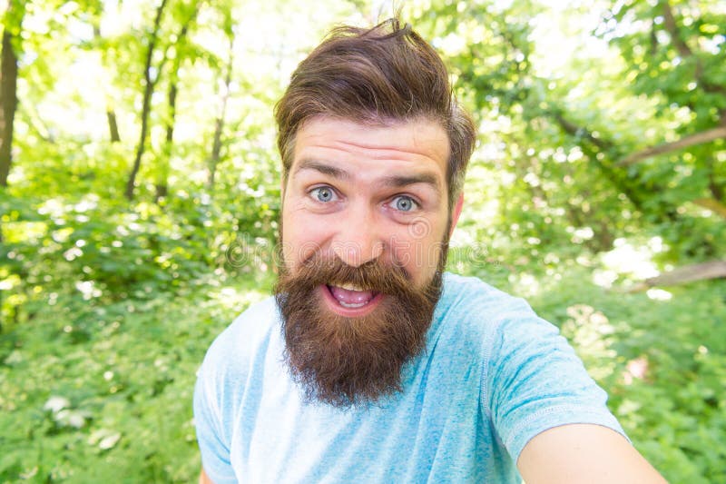 Go wild. Hair care male beauty. Summer fun. Bearded guy in park forest. Bearded hipster. Crazy bearded man in natural royalty free stock image Go wild. Hair care male beauty. Summer fun. Bearded guy in park forest. Bearded hipster. Crazy bearded man in natural royalty free stock image