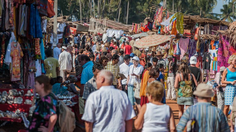 Goa, Indien - Januari 2008 - turister och lokala affärsmän på den berömda veckoloppmarknaden i Anjuna royaltyfria foton Goa, Indien - Januari 2008 - turister och lokala affärsmän på den berömda veckoloppmarknaden i Anjuna royaltyfria foton