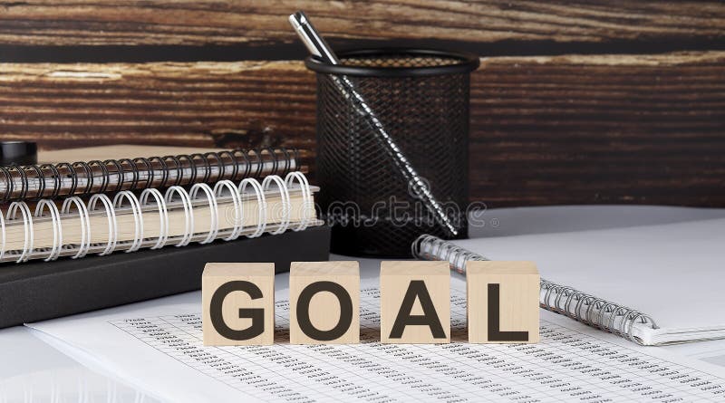 GOAL text on the wooden block with notebooks on the chart