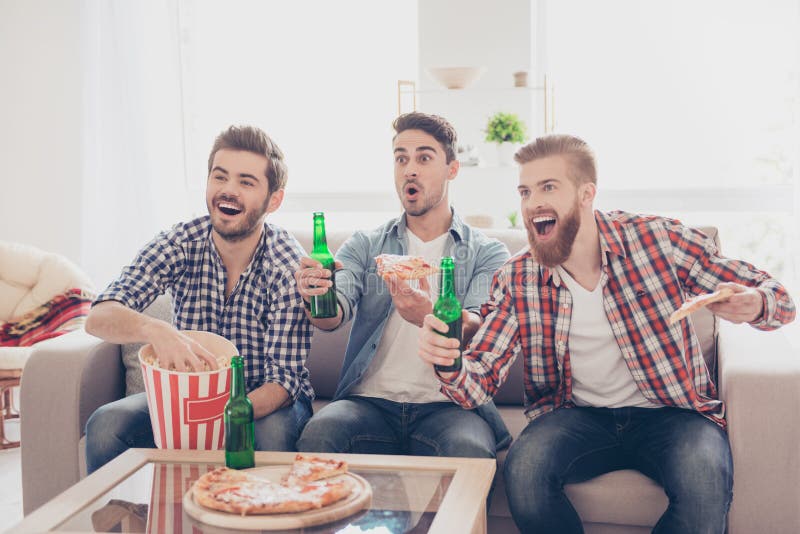 Young bearded guys are having fun, watching match and. 