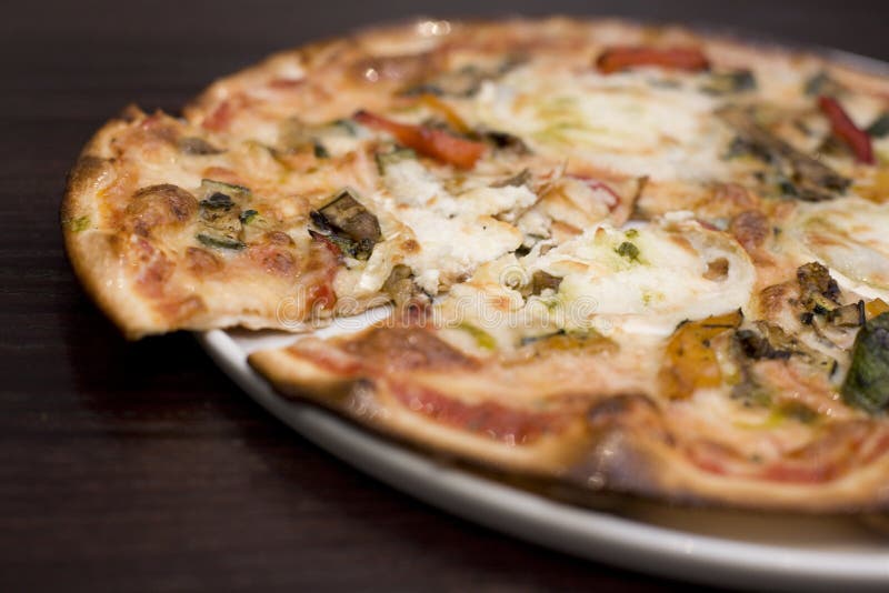 Un bagno di stile, formaggio di capra e arrosto vegatable pizza.