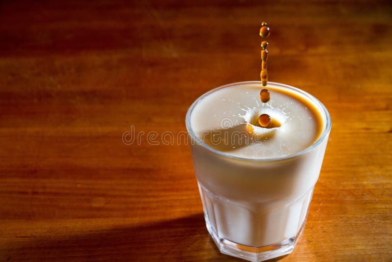 Drops of coffee splashing in a glass of milk, high speed. Drops of coffee splashing in a glass of milk, high speed