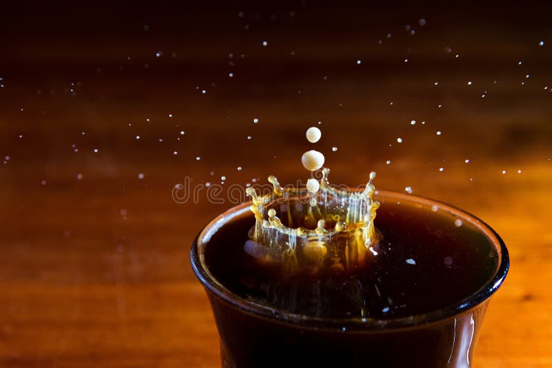 Drops of milk splashing in a cup of coffee, high speed. Drops of milk splashing in a cup of coffee, high speed