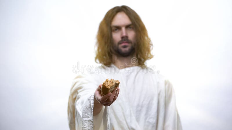 God Jesus som håller ut bröd, religiöst koncept för att ge mat till hungriga och fattiga arkivbild God Jesus som håller ut bröd, religiöst koncept för att ge mat till hungriga och fattiga arkivbild