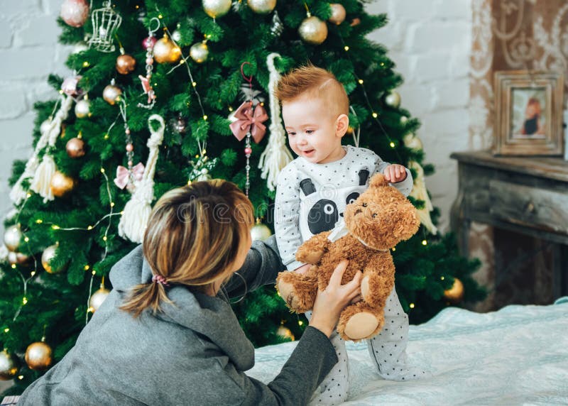 God jul och glada semester. Underbar mamma och hennes söta, ettåriga son som har kul och leker tillsammans hemma royaltyfri bild