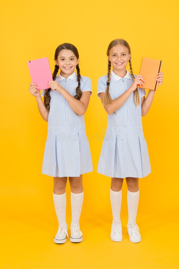 Goda vänner i återo-uniform vintage killmode tillbaka till skolan små flickor har arbetsbok och anteckningsblock encyklopedi