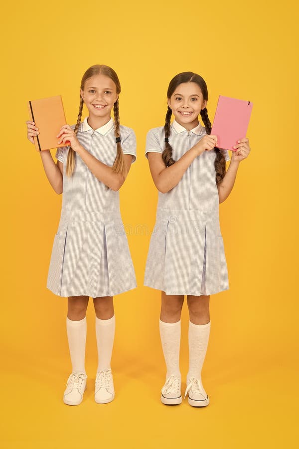 Goda vänner i återo-uniform vintage killmode tillbaka till skolan små flickor har arbetsbok och anteckningsblock encyklopedi