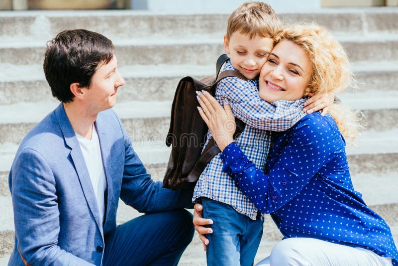 Godere del concetto 'nucleo familiare' Madre e papà che inviano la loro prima volta del ragazzo dell'allievo del bambino che stud immagini stock libere da diritti Godere del concetto 'nucleo familiare' Madre e papà che inviano la loro prima volta del ragazzo dell'allievo del bambino che stud immagini stock libere da diritti