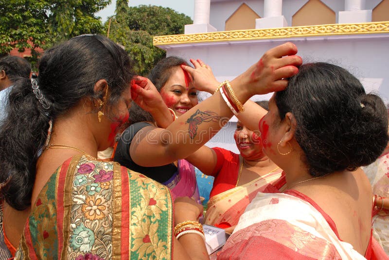 Beautiful Hindu women smear and play with vermilion during Sindur Khela traditional ceremony on the final day of Durga Puja festival. Beautiful Hindu women smear and play with vermilion during Sindur Khela traditional ceremony on the final day of Durga Puja festival