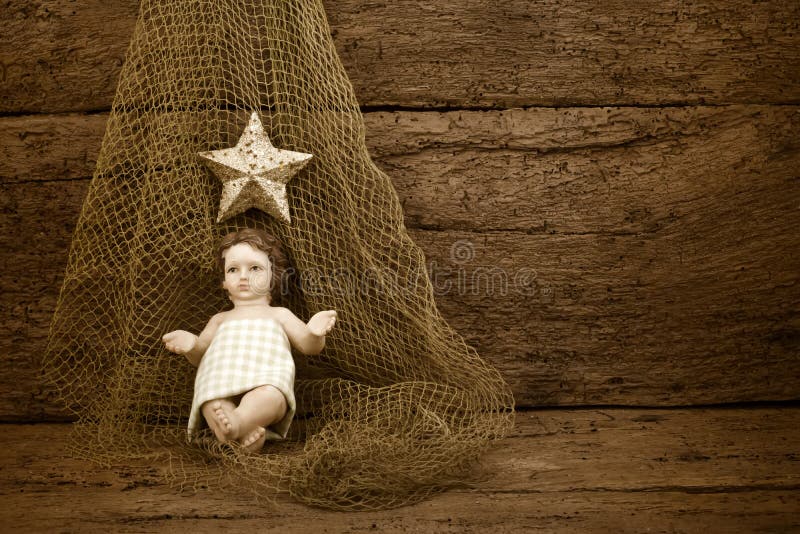 Christmas Child Jesus on a fishing net on old wooden background with blank space to write or photo. Christmas Child Jesus on a fishing net on old wooden background with blank space to write or photo