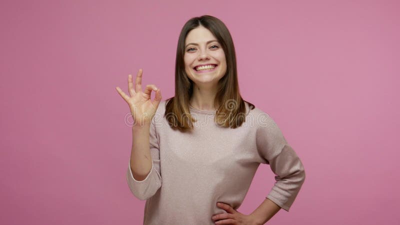 Goed gedaan! lieflijk tevreden brunette vrouw die lacht in het algemeen lacht en een teken van ok toont