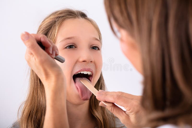 Gola irritata del dottore Checking Girl fotografia stock libera da diritti Gola irritata del dottore Checking Girl fotografia stock libera da diritti