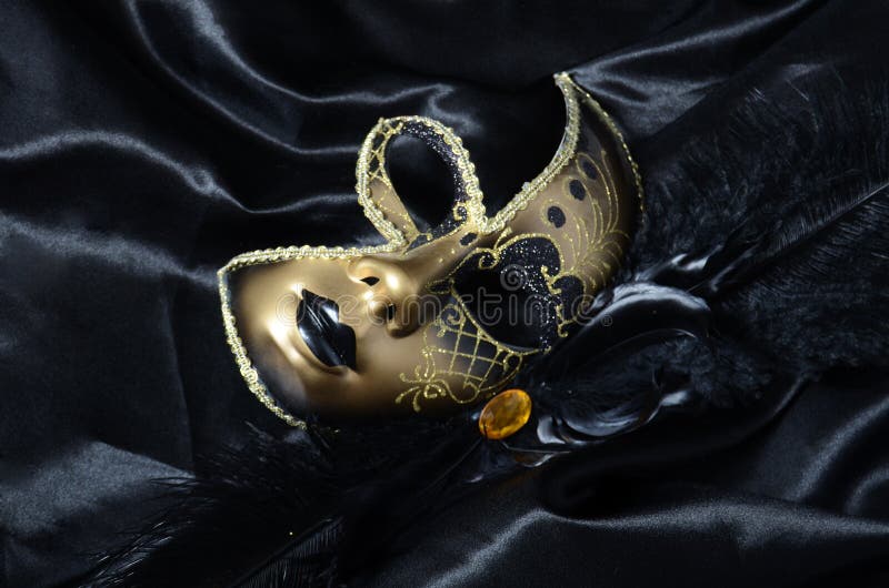 Gold a carnival mask with black feathers