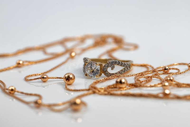 A Gold Chain with Gold Beads and a Large Diamond Ring Stock Photo
