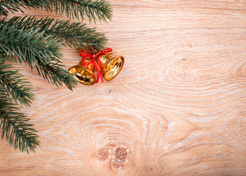 Gold Christmas bells and fir tree branch on a rustic wooden background stock photos Gold Christmas bells and fir tree branch on a rustic wooden background stock photos
