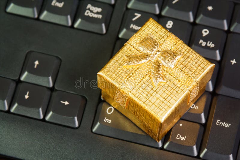Gold gift box on computer keyboard in online shopping concept stock photos Gold gift box on computer keyboard in online shopping concept stock photos