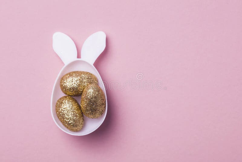 Gold Glitter Eggs in a White Easter Bunny Egg Shape with Ears Stock