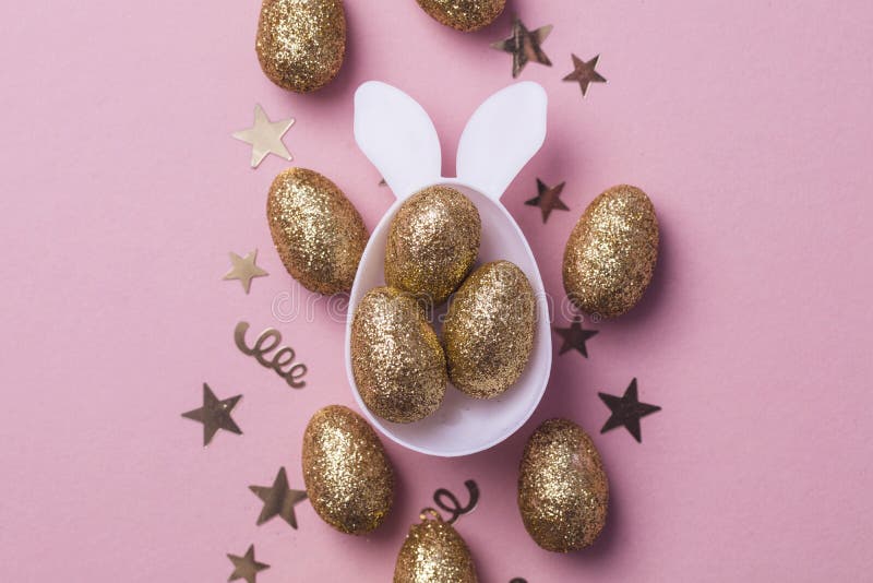 Gold Glitter Eggs in a White Easter Bunny Egg Shape with Ears Stock
