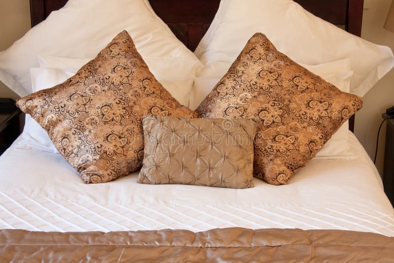 Gold pillows on white bed stock image. Image of satin 18417155