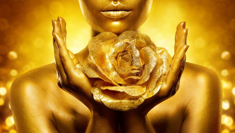 Gold Skin Woman Face. Golden Lips Make up with Flower close up. Female Hand Palms Holding Jewellery Rose over Shine Background