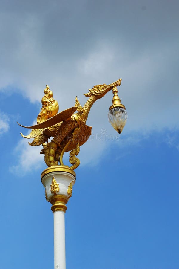 Gold swan bird on pole and sky