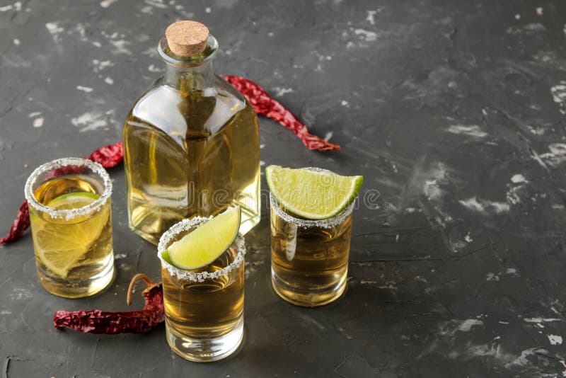 Gold Tequila in a Glass Shot Glass with Salt, Lime and Hot Pepper on a ...