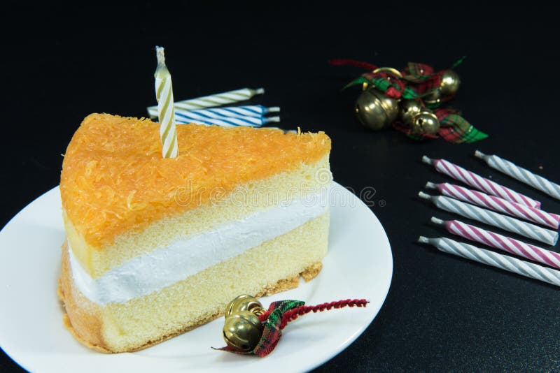 Gold Threads Cake and Bell Decoration and Candle on Texture Black Stock